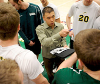 Coach talking to players huddled around